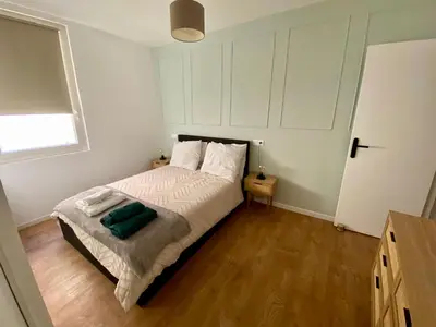 a bedroom with a bed with a green pillow on it at Chez Isa et Thomas in Narbonne