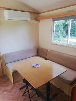 a small room with a table and a couch at Camping du Bois Fleuri in Fontiers-Cabardès
