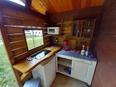 a kitchen in a tiny house with a counter at Camping du Bois Fleuri in Fontiers-Cabardès