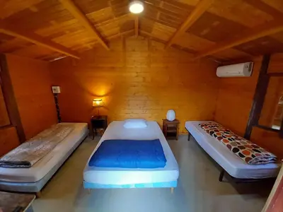 two beds in a room with wooden walls and ceilings at Camping du Bois Fleuri in Fontiers-Cabardès