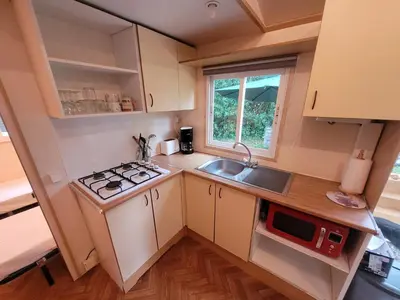 a small kitchen with a stove and a sink at Camping du Bois Fleuri in Fontiers-Cabardès