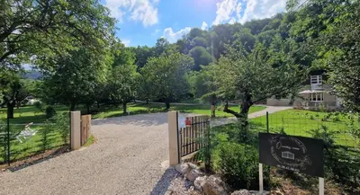 a gate in a park with a house in the background at Dortoir Gîte d'étapes 