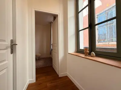 an empty room with a window and a hallway at Le Moderniste Proche des Halles et Cathédrale in Narbonne