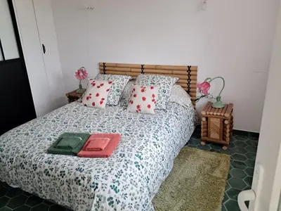 a bedroom with a bed with red and white pillows at Gentil coquelicot in Mirepoix