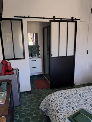 a bedroom with a bed and a black door at Gentil coquelicot in Mirepoix