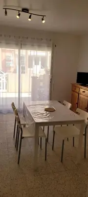 a white table and chairs in a room with a window at Superb T2 near the beach of Port-la-Nouvelle in Port-la-Nouvelle