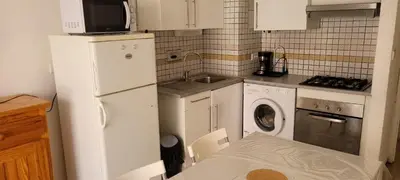 a kitchen with a white refrigerator and a washing machine at Superb T2 near the beach of Port-la-Nouvelle in Port-la-Nouvelle