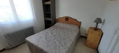 a small bedroom with a bed and a lamp at Superb T2 near the beach of Port-la-Nouvelle in Port-la-Nouvelle