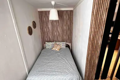 a small bed in a corner of a room at T3 6 couchages grands buffets et plages in Narbonne