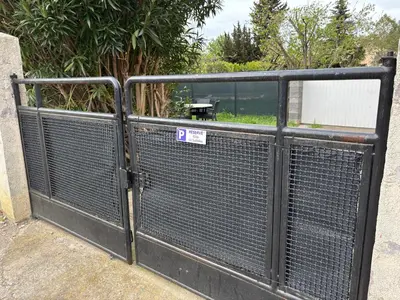 a metal gate with a sign on it at Gîte Le Sallèles in Sallèles-dʼAude