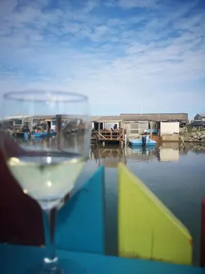a glass of wine sitting on top of a table at Appartement 600M de la plage in Port-la-Nouvelle