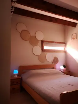 a bedroom with a bed and a window with circles on the wall at Appartement 600M de la plage in Port-la-Nouvelle