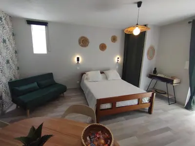 a living room with a bed and a couch at Entre canal et garrigue in Roubia