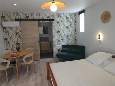 a room with a bed and a table and a couch at Entre canal et garrigue in Roubia