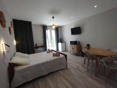 a living room with a bed and a dining room table at Entre canal et garrigue in Roubia