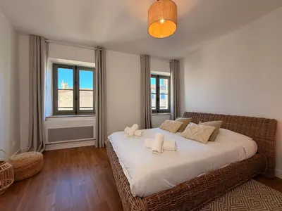a bedroom with a large bed with white sheets and pillows at Le Saint Just T2 proche des Halles Wifi in Narbonne