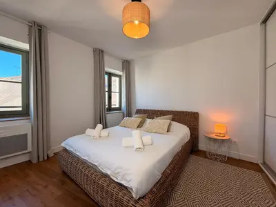 a bedroom with a bed with white sheets and pillows at Le Saint Just T2 proche des Halles Wifi in Narbonne