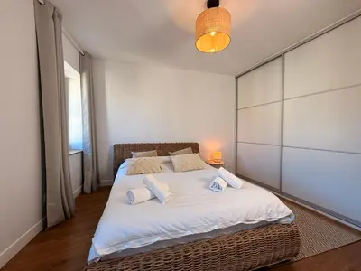 a bedroom with a large bed with white sheets and pillows at Le Saint Just T2 proche des Halles Wifi in Narbonne