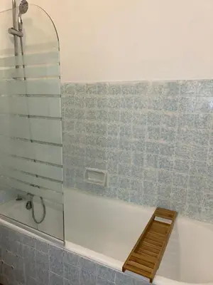a bathroom with a tub and a glass shower at Spacieux T2 climatisé Narbonne - Près du centre ville in Narbonne