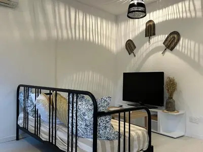 a bedroom with a bed and a tv on a wall at Spacieux T2 climatisé Narbonne - Près du centre ville in Narbonne