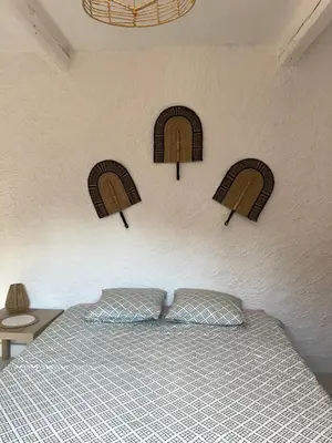 a bedroom with a bed with four arches on the wall at Spacieux T2 climatisé Narbonne - Près du centre ville in Narbonne