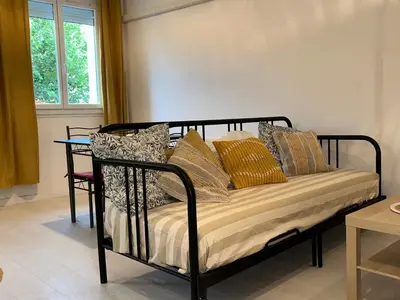 a black bed with pillows on it in a room at Spacieux T2 climatisé Narbonne - Près du centre ville in Narbonne