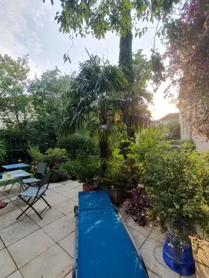 a patio with a blue slide in a garden at Le Clos Ste Anne in Bizanet