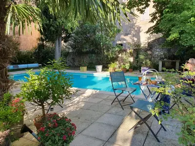a patio with a table and chairs next to a pool at Le Clos Ste Anne in Bizanet