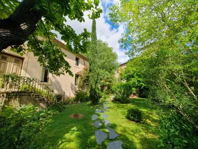 a garden with a stone path in front of a house at Le Clos Ste Anne in Bizanet