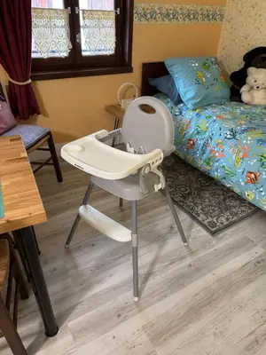a baby high chair in a bedroom with a bed at Chambre Lits Jumeaux in Mirepoix