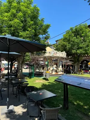 a park with tables and chairs and an umbrella at Chambre Lits Jumeaux in Mirepoix