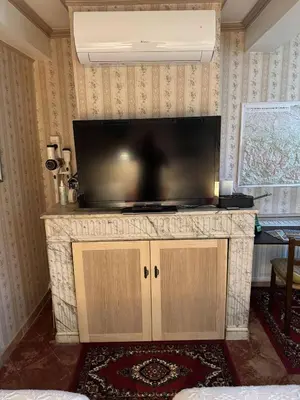 a large flat screen tv on a stand in a living room at Chambre Lits Jumeaux in Mirepoix