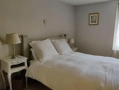 a white bed with white pillows and a lamp on a table at Ceps Cottage sleeps 6 with free wifi near the river in Roquebrun