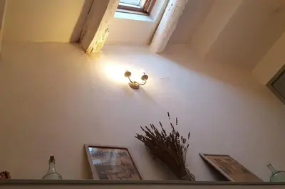 a light on a wall with pictures and a window at Ceps Cottage sleeps 6 with free wifi near the river in Roquebrun