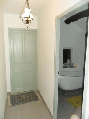 a bathroom with a white door and a bath tub at Ceps Cottage sleeps 6 with free wifi near the river in Roquebrun
