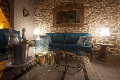 a living room with a couch and a table with wine glasses at Le Grenier in Carcassonne