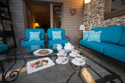 a patio with blue couches and a table with food on it at Le Grenier in Carcassonne