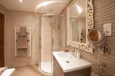 a bathroom with a sink and a shower and a mirror at Le Grenier in Carcassonne