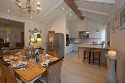a kitchen and dining room with a wooden table with chairs at Le Grenier in Carcassonne