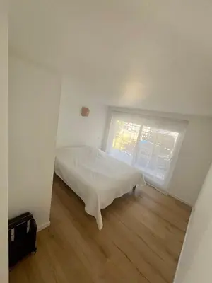 a bedroom with a white bed and a window at Charmant et Confortable appartement Narbonne in Narbonne