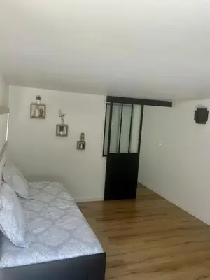 a bedroom with a bed in a room with a wooden floor at Charmant et Confortable appartement Narbonne in Narbonne