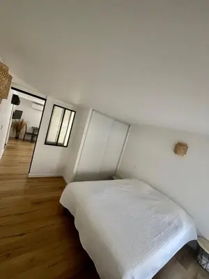 a bedroom with a white bed in a room at Charmant et Confortable appartement Narbonne in Narbonne
