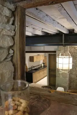 a kitchen with a counter and a table with a glass at L'Echauguette, villa de luxe avec piscine au pied de la Cité in Carcassonne
