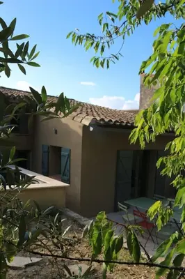 a house is shown through the leaves of trees at L'Echauguette, villa de luxe avec piscine au pied de la Cité in Carcassonne