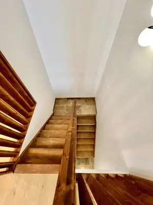 a staircase in a room with wooden floors and white walls at Le Margaux Balnéo spacieux calme in Conques-sur-Orbiel