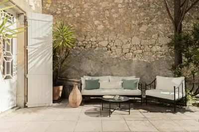a patio with a couch and two chairs and a table at Maison Esme - Charm & Authenticity in Salles-d'Aude
