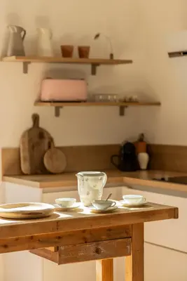 a table in a kitchen with bowls and plates on it at Maison Esme - Charm & Authenticity in Salles-d'Aude