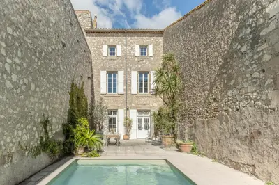 a living room with a white couch and a television at Maison Esme - Charm & Authenticity in Salles-d'Aude