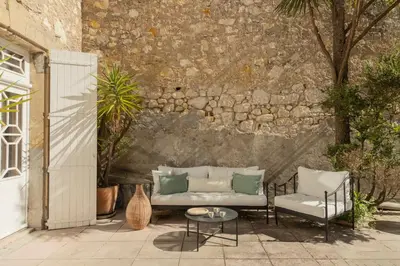 a patio with a couch and chairs and a table at Maison Esme - Charm & Authenticity in Salles-d'Aude