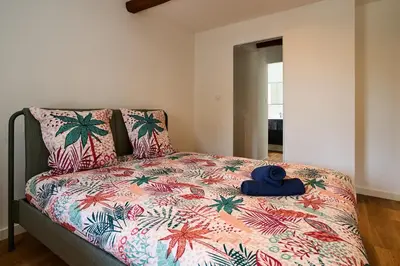 a bed with a blue teddy bear on top of it at Le Rempart Harmonieux - Triplex au pied de la Cité in Carcassonne